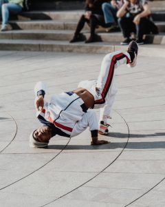  Dançarino de breakdance vestindo roupa feita com tecidos resistentes e tecnológicos, oferecendo alta performance e durabilidade.